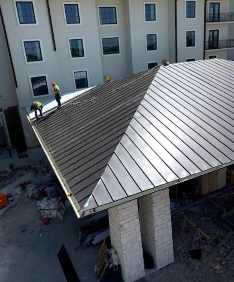 Crew installing standing seam metal roof panels on a commercial project in Franklin Park